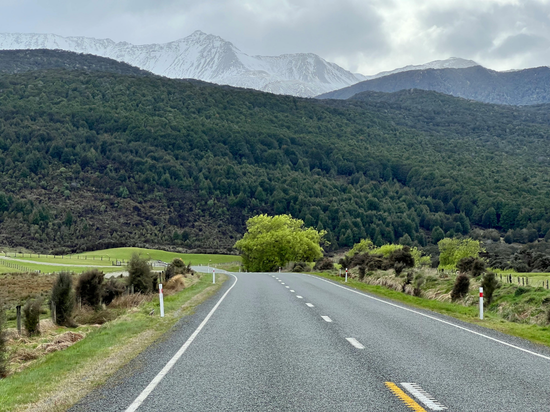 An open road running toward mountains in the New Zealand landscape